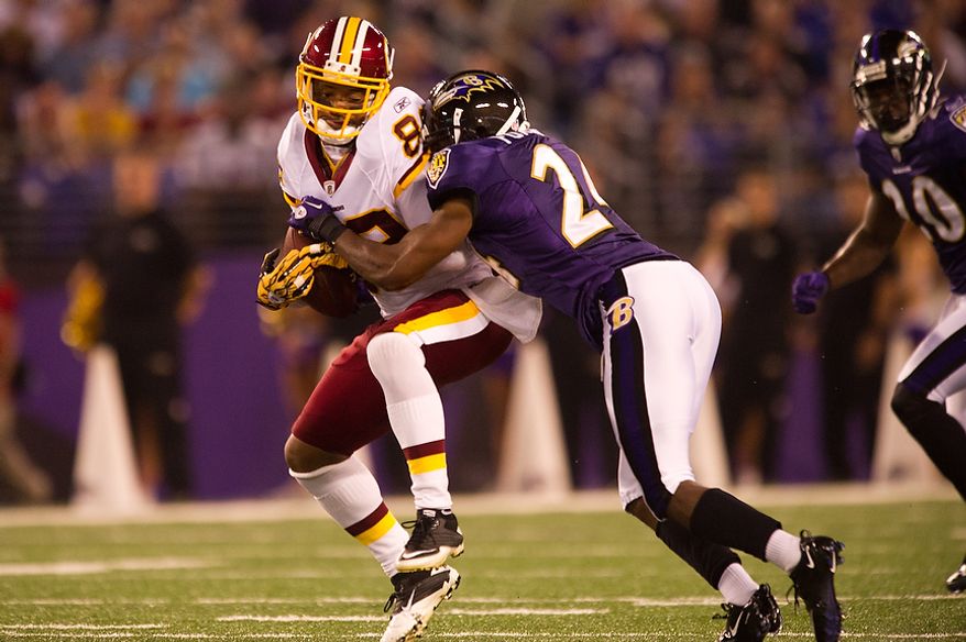 Receiver Santana Moss of the Washington Redskins is hit hard on a short pass by cornerback Domonique Foxworth of the Baltimore Ravens in  preseason football at M&amp;T Bank Stadium in Baltimore, MD, Thursday, August 25, 2011. (Andrew Harnik / The Washington Times)