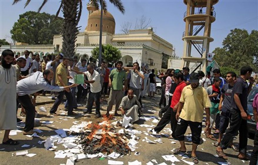 Rebel supporters burn Green books in the main square of the Qasr Bin Ghashir district in Tripoli, Libya, Saturday, Aug. 27, 2011. Libyan rebel leaders say they have taken control of a strategic border crossing with Tunisia, but are still meeting resistance from regime loyalists along the coastal road between the border and the capital. (AP Photo/Sergey Ponomarev)