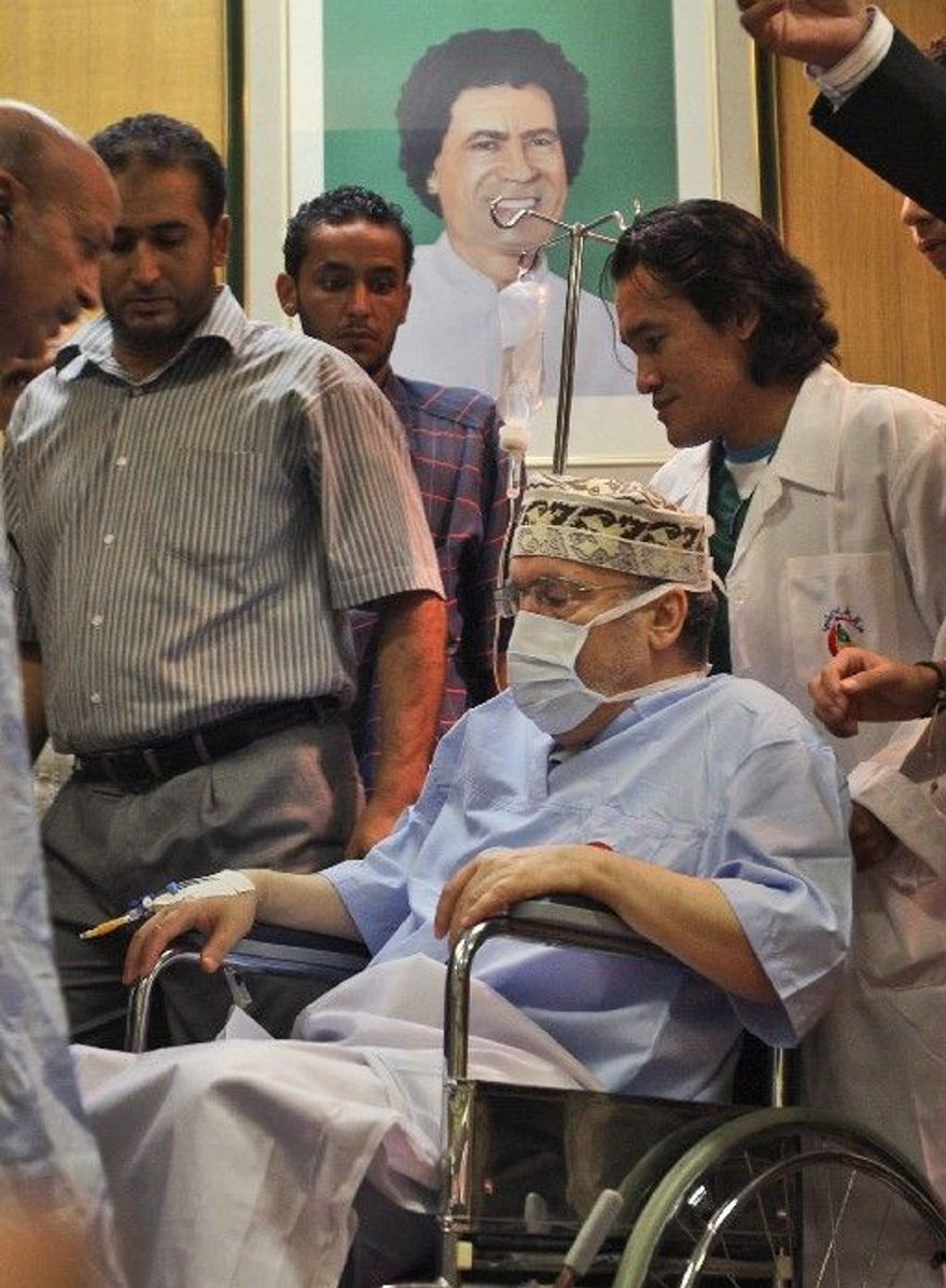 ASSOCIATED PRESS
Abdel Baset al-Megrahi, who was found guilty of the 1988 Lockerbie bombing but released on compassionate grounds, is seen below a portrait of Moammar Gadhafi as he is visited by African parliamentarians at Tripoli Medical Center.