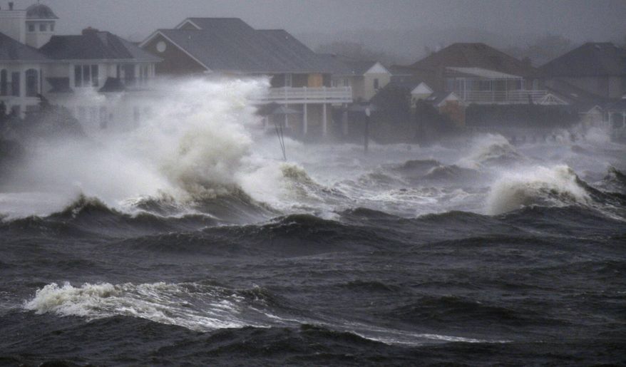 Waves from a storm surge from Hurricane Irene crash over the shore during high tide in Bayshore, N.Y., on Long Island on Sunday, Aug. 28, 2011. (AP Photo/Charles Krupa)