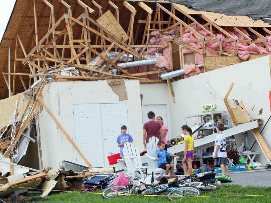 People look over the damage to Sue and Jack Holloway's home on Crab Apple Court in the Nassau Station development in Lewis, Del. Sunday, Aug. 28, 2011. (AP Photo/The News Journal, Suchat Pederson)