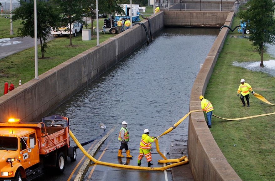 Virginia Dept. of Transportation workers place hose to pump out floodwater at the entrance of Midtown Tunnel prior to its scheduled opening in Norfolk, Va. Sunday morning, Aug. 28, 2011. (AP Photo/The Virginia-Pilot, Hyunsoo Leo Kim) MAGS OUT