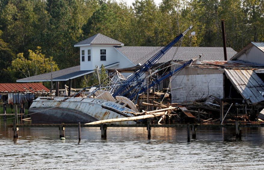 A shrimp boat is bashed against the dock of Daniel's Seafood at the shoreline of the Pamilco River near Aurora, N.C., Sunday, Aug. 28, 2011 after Hurricane Irene hit the North Carolina coast. (AP Photo/Chuck Burton)