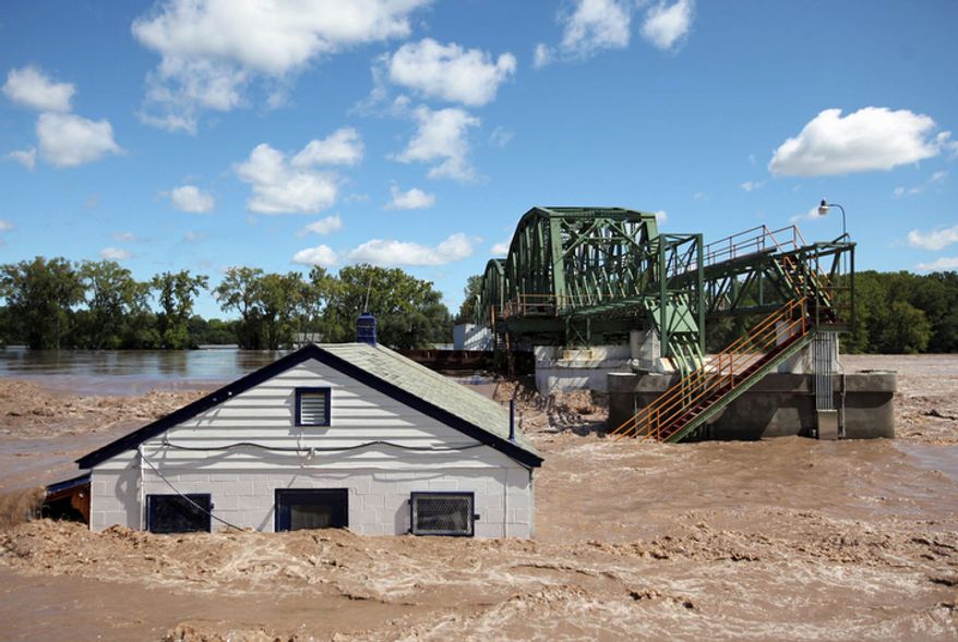 Lock 8 in Rotterdam, N.Y. overflows with water, and a metal barge is crashed into the gates, on Monday, Aug. 29, 2011 during extensive flooding in the region as a result of Tropical Storm Irene. (AP Photo/The Daily Gazette, Patrick Dodson)