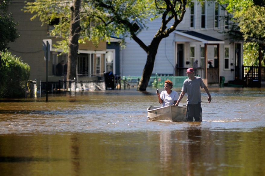 Greg Walker pulls a woman with his canoe north on Winnikee Ave. in Poughkeepsie, N.Y. after the Fallkill Creek flooded large areas in the north side of the city Monday, Aug. 29, 2011. (AP Photo/The Journal, Spencer Ainsley)