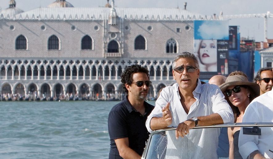 &quot;The Ides of March&quot; director, writer and actor George Clooney (second from left) arrives in Venice on Tuesday with co-writer Grant Heslov (left). The political drama, which also stars Ryan Gosling, Paul Giamatti, Philip Seymour Hoffman and Marisa Tomei, opened the Venice Film Festival on Wednesday. (Associated Press)