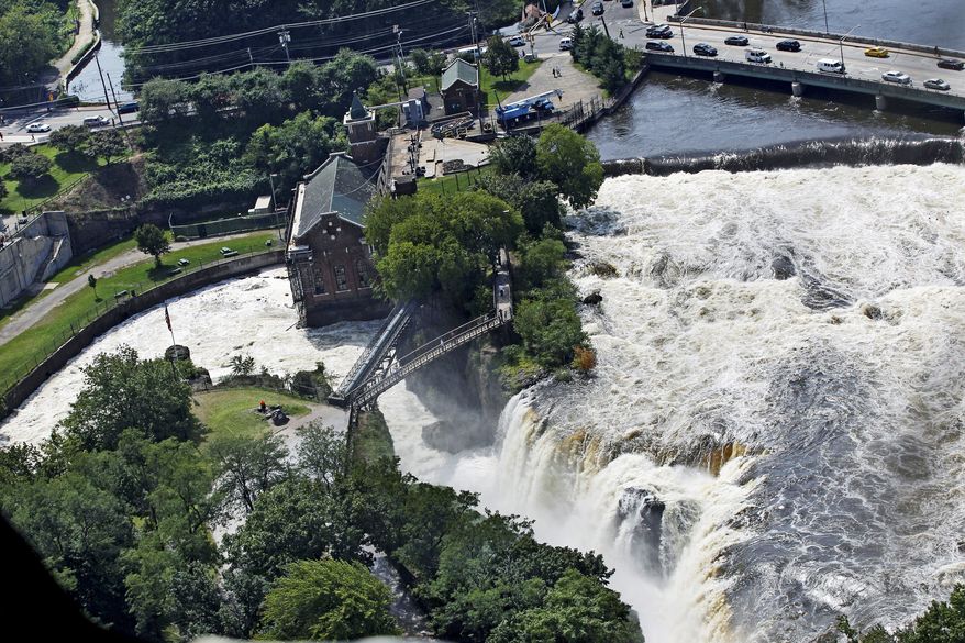 associated press photographs
In Paterson N.J. on Thursday, people on a foot bridge watch the Great Falls of the Passaic River roar with water after Hurricane Irene. Flooding continues to hamper recovery efforts in northern New Jersey. Paterson got more than 8 inches of rain from the storm and the subsequent flooding was the worst in more than a century.