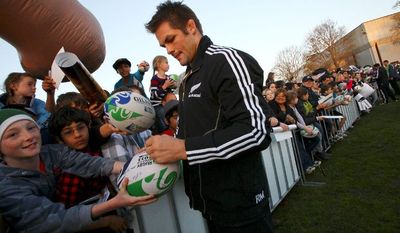 ASSOCIATED PRESS PHOTOGRAPHS
New Zealand All Blacks captain Richie McCaw signs his name on a rugby ball for a child during a fan event Sunday ahead of the seven-week Rugby World Cup in Auckland, New Zealand. In a country of 4 million, rugby has been the most important game for more than 100 years.