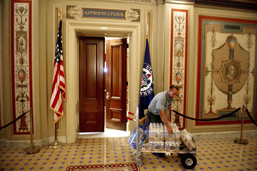 Senate Facilities Services technician Carlos Abarca delivers cases of bottled water to the Appropriations Committee in July. One internal cost-saving measure Congress hasn't yet availed itself of is to opt instead for D.C. tap water. (Rod Lamkey Jr./The Washington Times)