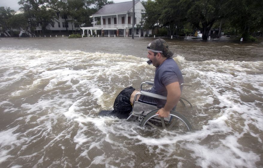 Cecil Flemming tries to maneuver his wheelchair through the floodwaters on the shore of Lake Pontchartrain in Mandeville, La., after water crashed over the seawall from Tropical Storm Lee on Sunday, Sept. 4, 2011. (AP Photo/New Orleans Times-Picayune, Ted Jackson)