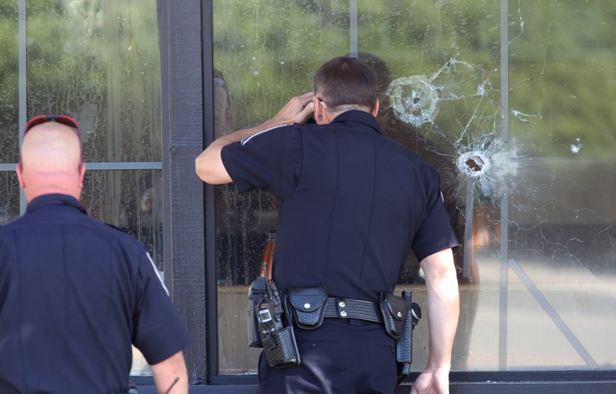 Police officers look through a bullet-damaged window of an IHOP restaurant in Carson City, Nev., on Tuesday, Sept. 6, 2011. (AP Photo/Cathleen Allison)