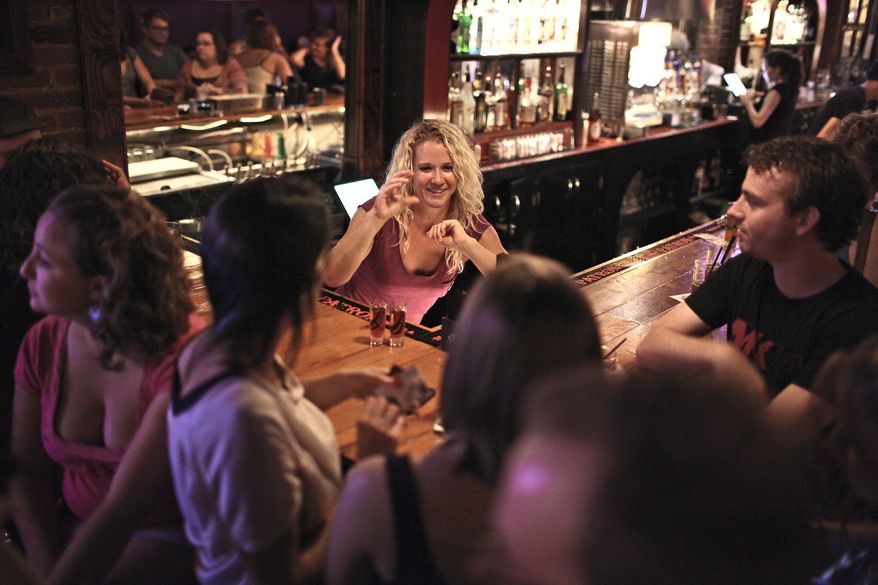 HELPING HANDS: Bartender Leah Mackie has learned to sign bar-specific words, the alphabet and the lyrics to a few songs so she can communicate with her hearing-impaired patrons at H Street Country Club in Northeast. (Andrew Harnik/The Washington Times)