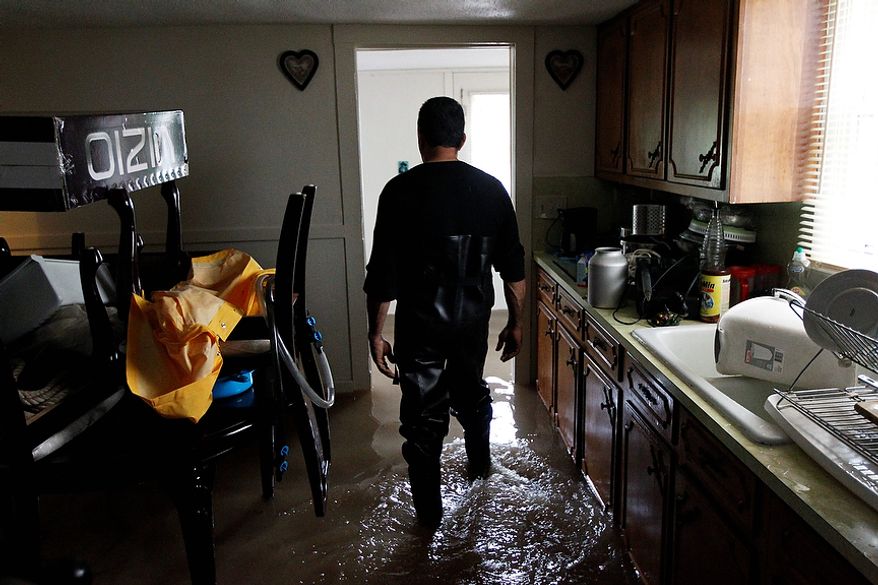 Mario Ortiz, walks through floodwaters in his kitchen Thursday, Sept. 8, 2011, in Wilkes-Barre, Pa. Widespread flooding brought on by the remnants of Tropical Storm Lee was being blamed for two deaths in Pennsylvania, where inundated communities were evacuated and state offices closed down on Thursday because of the rising waters. (AP Photo/Matt Rourke)