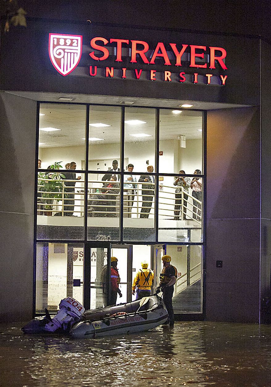 ** FILE ** Firefighters begin to evacuate students at Strayer University who have become trapped by floodwaters in Alexandria on Thursday, Sept. 8, 2011. (Andrew S. Geraci/The Washington Times)