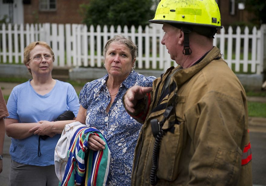 Huntington neighborhood residents Nancy Foote (left) and Meredith Ellsworth (center) talk with a Fairfax County official on Sept. 9, 2011, as they and other residents attempted to clean up from the flooding on Arlington Terrace in the Huntington neighborhood of Alexandria, Va. (Rod Lamkey Jr./The Washington Times)