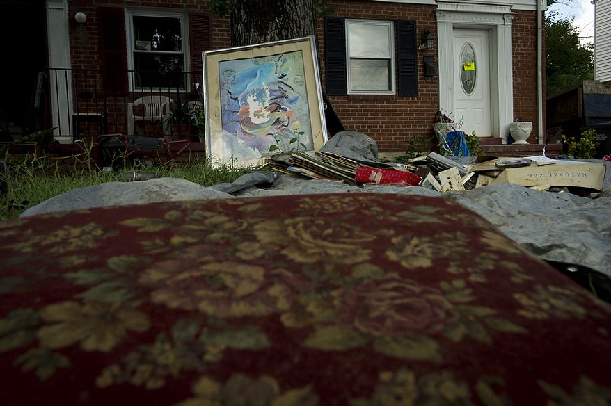 Flood-damaged personal belongings from the Boyd family home dry out on the front lawn on Sept. 9, 2011, as residents cleaned up from the flooding on Arlington Terrace in the Huntington neighborhood of Alexandria, Va., after heavy rains pounded the region. (Rod Lamkey Jr./The Washington Times)