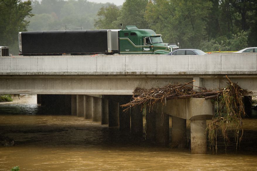 Debris is trapped Sept. 9, 2011, on an Interstate 495 bridge over Camden Run near Eisenhower Avenue in Alexandria, Va., which was flooded after heavy rains pounded the region. (Andrew Harnik/The Washington Times)