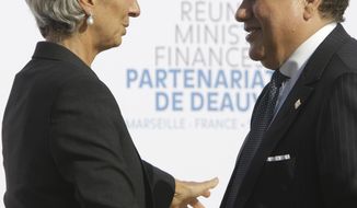 International Monetary Fund (IMF) managing director Christine Lagarde, left, talks with Tunisian Finance Minister Jelloul Ayed during the group photo at the Deauville partnership meeting in Marseille, southern France, Saturday, Sept.10, 2011. (AP Photo/Lionel Cironneau)