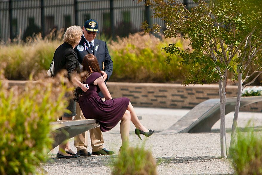 Sara Guest (left) and her husband, Jackson, comfort Toni Guest, 21, all of Watkinsville, Ga., as the family visits the Pentagon Memorial on Sunday, Sept. 11, 2011, following the commemoration of the Sept. 11, 2001, attack on the Pentagon in Arlington. Sara Guest's sister, Leslie Whittington, was killed in the attack, along with Leslie's husband, Charlie, and their daughters, Zoe Falkenberg, 8, and Dana Falkenberg, 3. (T.J. Kirkpatrick/The Washington Times)