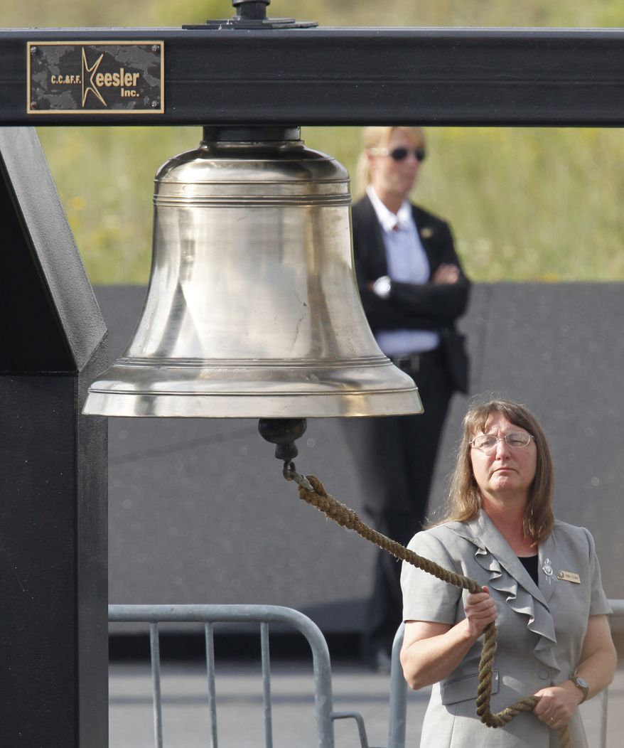 A bell is rung during the reading of the names of passengers and crew who died aboard Flight 93 on Sept. 11, 2001. Memorial services were held near the crash site in Shanksville, Pa., on Sunday, Sept. 11, 2011. (AP Photo/Gene J. Puskar)
