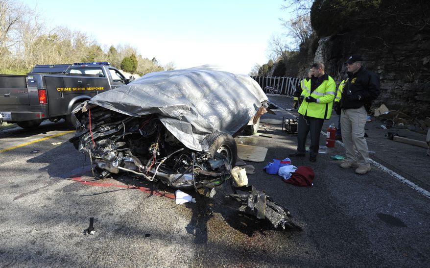 ** FILE ** Kentucky State Police officers investigate an accident involving a tractor-trailer and a van on Interstate 65, four miles north of Horse Cave, Ky., on March 26, 2010. The crash killed 11 people, including the truck driver, who the National Transportation Safety Board says was using his cellphone at the time. (AP Photo/Daily News, Joe Imel)