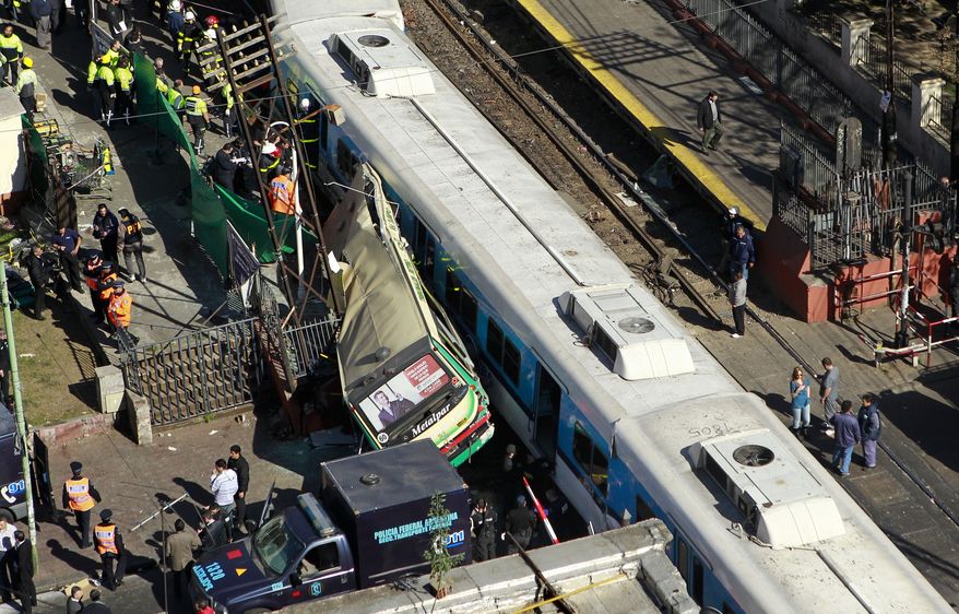 A passenger train hit a bus, the driver of which had driven around barriers in an attempt to beat the train, and then crashed head-on into another train at a station in Buenos Aires on Tuesday, Sept. 13, 2011. (AP Photo/Victor R. Caivano)