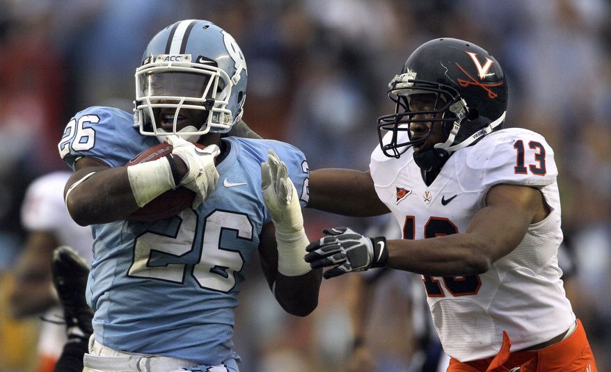 North Carolina's Giovani Bernard runs the ball as Virginia's Chase Minnifield (13) tries to make the tackle during the second half of an NCAA college football game in Chapel Hill, N.C. on Saturday, Sept. 17, 2011. North Carolina won 28-17, and Bernard had 102 yards rushing. (AP Photo/Gerry Broome)