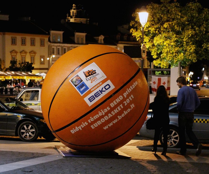 In Vilnius, a giant basketball dwarfs cars and people in a large open square in the city's ancient old town. (Christopher Johnson/Special to The Washington Times)