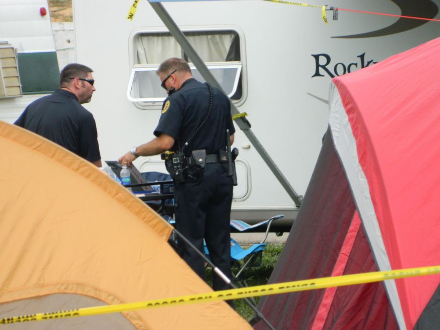 Police survey a trailer where five people were found dead on Sunday, Sept. 18, 2011, at the Clarksville Speedway in Clarksville, Tenn. The deaths brought an abrupt halt to the celebration of the state's largest toy run for needy children, which was hosted Saturday at the speedway by Bikers Who Care. (AP Photo/The Leaf-Chronicle, Luke Thompson)