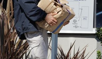 An FBI agent carries out evidence from Solyndra headquarters in Fremont, Calif., on Sept. 8 in a probe of its collapse after receiving $535 million in federal loans. (Associated Press)