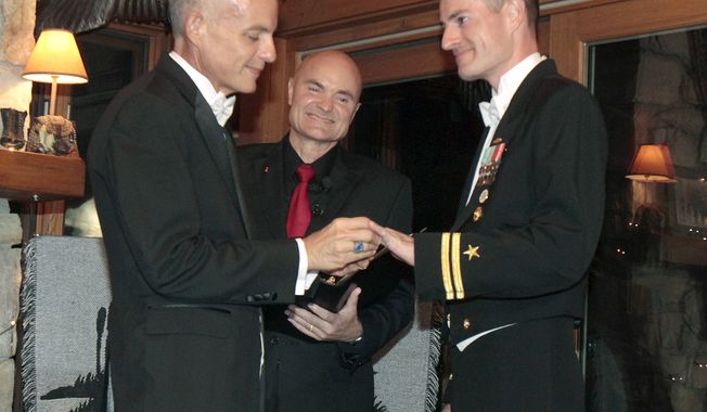 **FILE** Navy Lt. Gary Ross (right) and Dan Swezy exchange wedding vows early on Sept. 20, 2011, in Duxbury, Vt., at the first possible moment after the formal repeal of the military&#x27;s &quot;don&#x27;t ask, don&#x27;t tell&quot; policy. Justice of the Peace Greg Trulson (center) officiated. (Associated Press)