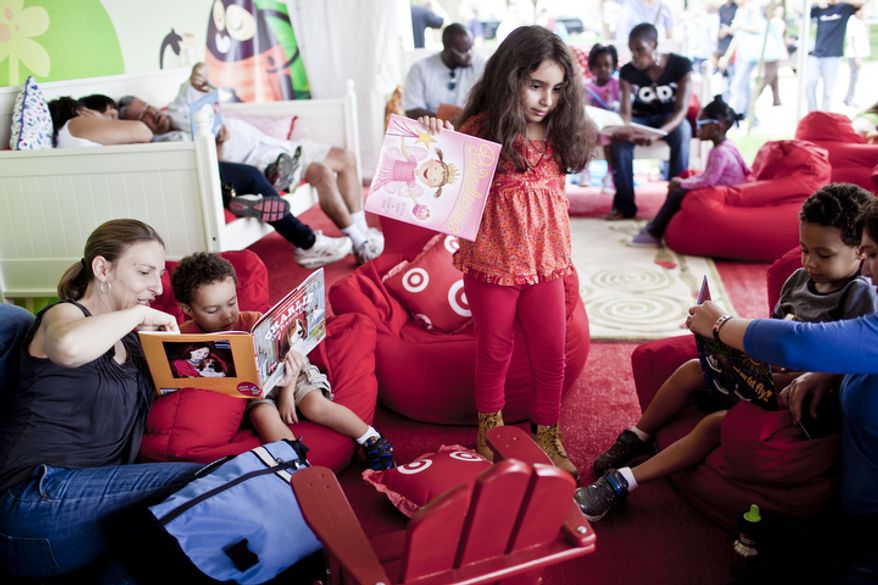 Kerri DiZoglio, left, of Takoma Park, Md., reads to her son Alec Barrera, 2, as her son Jaeden Barrera, 4, reads with Theresa Bosanek, at right, while Julia Brunetti, 6, center, of Bethesda, Md., gets up to find a new book in a family storytelling tent at the National Book Festival.
(T.J. Kirkpatrick/ The Washington Times)