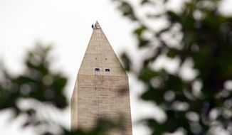 Dave Megerle, a member of Wiss, Janney, Elstner Associates&#x27; &quot;difficult-access team,&quot; shuns fear of heights — in this case, 555 feet — atop the Washington Monument on Tuesday. (Rod Lamkey Jr./The Washington Times)