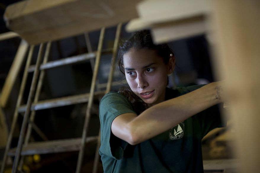 Alexandria Seaport Foundation apprentice and graduate Lisa Lukshaw, the only female apprentice in the program today, moves long pieces of lumber at the Alexandria Seaport Foundation in Alexandria, Va., Tuesday, July 5, 2011. Located on the waterfront in Old Town Alexandria, the Alexandria Seaport Foundation is a non-profit paid apprenticeship and hands-on educational program which serves at-risk youths ages 17-21. In the program these youths learn life skills, team work and building their self esteem. In the program apprentices learn carpentry skills and planing for career paths, in addition to earning their GED right here. The ASF says that it costs $100,000.00 to detain a juvenile for a year in Virginia, but only $15,000.00 to educate and place an ASF apprentice. The paid staff and numerous volunteers teaches approximately 8-16 students, however today they are working with around 10. The program lasts 5 to 8 months. Every Tuesday night is "Open Shop" a time when the shop is open to the public. (Rod Lamkey Jr/The Washington Times)