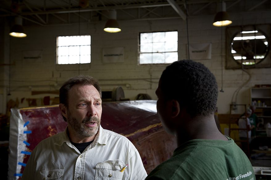 Fred Geiger, a former DEA agent and current volunteer, advises apprentice Darel Bellamy at the Alexandria Seaport Foundation in Alexandria, Va., Wednesday, August 3, 2011. Darel thinks of Mr. Geiger as a "second dad". Located on the waterfront in Old Town Alexandria, the Alexandria Seaport Foundation is a non-profit paid apprenticeship and hands-on educational program which serves at-risk youths ages 17-21. In the program these youths learn life skills, team work and building their self esteem. In the program apprentices learn carpentry skills and planing for career paths, in addition to earning their GED right here. The ASF says that it costs $100,000.00 to detain a juvenile for a year in Virginia, but only $15,000.00 to educate and place an ASF apprentice. The paid staff and numerous volunteers teaches approximately 8-16 students, however today they are working with around 10. The program lasts 5 to 8 months. Every Tuesday night is "Open Shop" a time when the shop is open to the public. (Rod Lamkey Jr/The Washington Times)