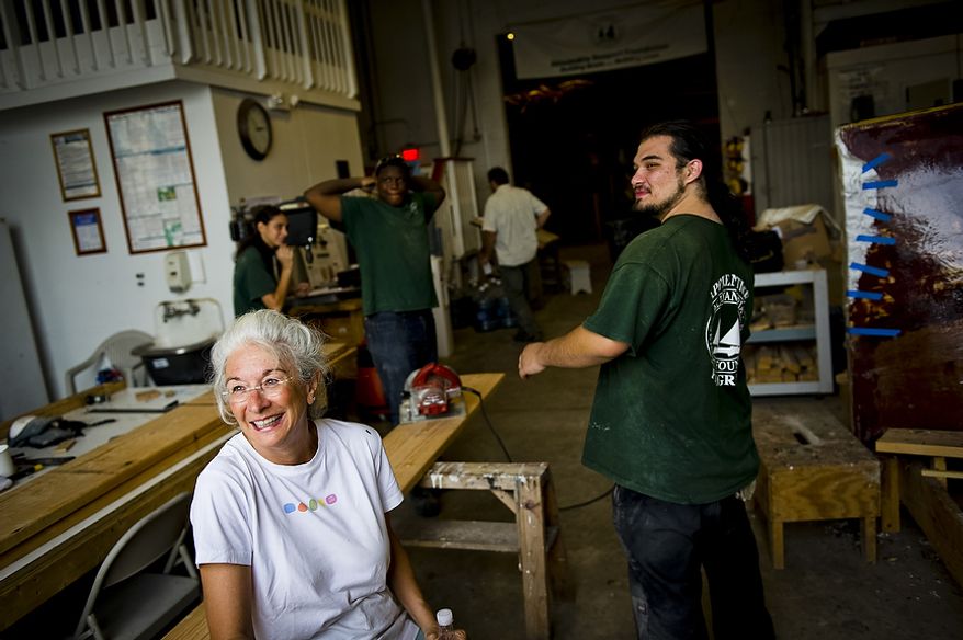 Alexandria Seaport Foundation volunteer Jimmy Cook (left) shares a laugh with apprentice Samuel Morrill (right) as she takes a break from work as well at the Alexandria Seaport Foundation in Alexandria, Va., Wednesday, August 3, 2011. Located on the waterfront in Old Town Alexandria, the Alexandria Seaport Foundation is a non-profit paid apprenticeship and hands-on educational program which serves at-risk youths ages 17-21. In the program these youths learn life skills, team work and building their self esteem. In the program apprentices learn carpentry skills and planing for career paths, in addition to earning their GED right here. The ASF says that it costs $100,000.00 to detain a juvenile for a year in Virginia, but only $15,000.00 to educate and place an ASF apprentice. The paid staff and numerous volunteers teaches approximately 8-16 students, however today they are working with around 10. The program lasts 5 to 8 months. Every Tuesday night is "Open Shop" a time when the shop is open to the public. (Rod Lamkey Jr/The Washington Times)