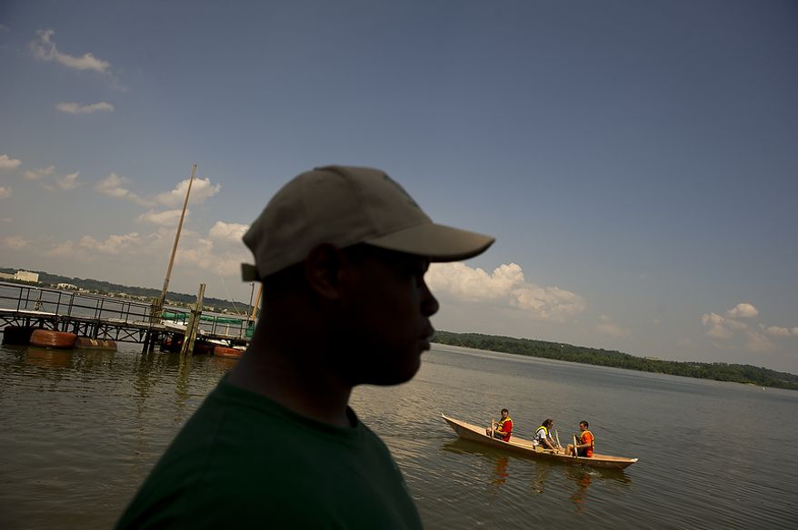 Darel Bellamy watches as visiting law student interns row out into the Potomac River in a boat that he and other apprentices helped them to build at the Alexandria Seaport Foundation in Alexandria, Va., Tuesday, June 28, 2011. Located on the waterfront in Old Town Alexandria, the Alexandria Seaport Foundation is a non-profit paid apprenticeship and hands-on educational program which serves at-risk youths ages 17-21. In the program these youths learn life skills, team work and building their self esteem. In the program apprentices learn carpentry skills and planing for career paths, in addition to earning their GED right here. The ASF says that it costs $100,000.00 to detain a juvenile for a year in Virginia, but only $15,000.00 to educate and place an ASF apprentice. The paid staff and numerous volunteers teaches approximately 8-16 students, however today they are working with around 10. The program lasts 5 to 8 months. Every Tuesday night is "Open Shop" a time when the shop is open to the public. (Rod Lamkey Jr/The Washington Times)