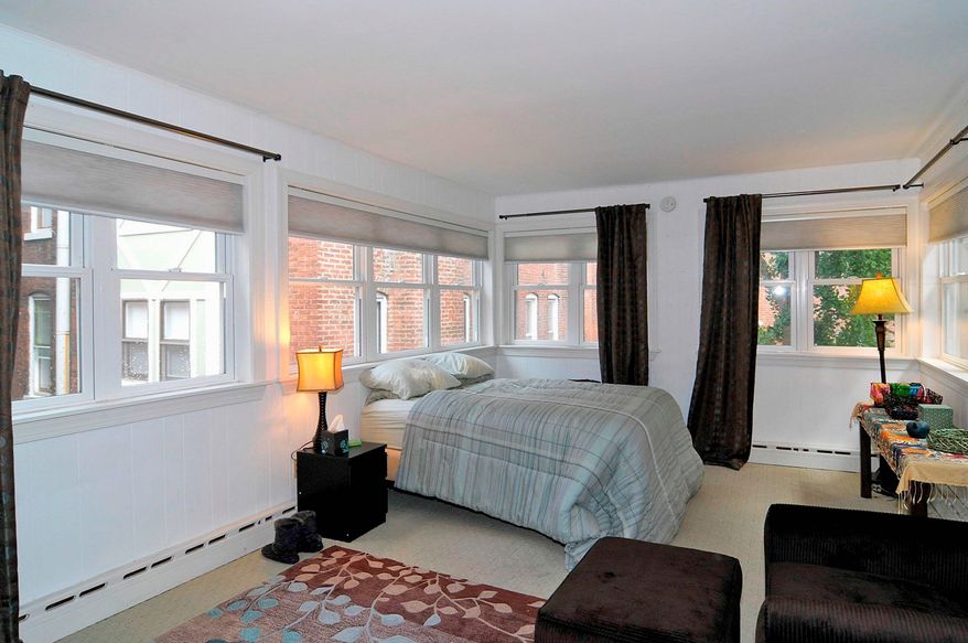 The home has six bedrooms: two on the first of two upper levels, three on the top level and one on the lower level. At the center of the main level is an open hall between the living room and dining room.