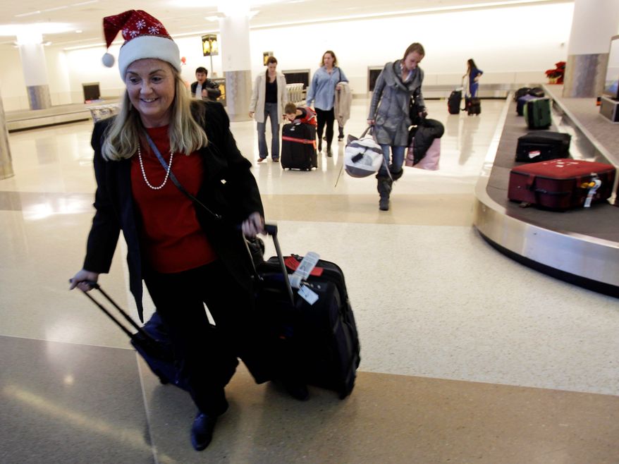 **FILE** Holiday travelers collect their luggage Dec. 21, 2010, at the San Jose International Airport in San Jose, Calif. (Associated Press)