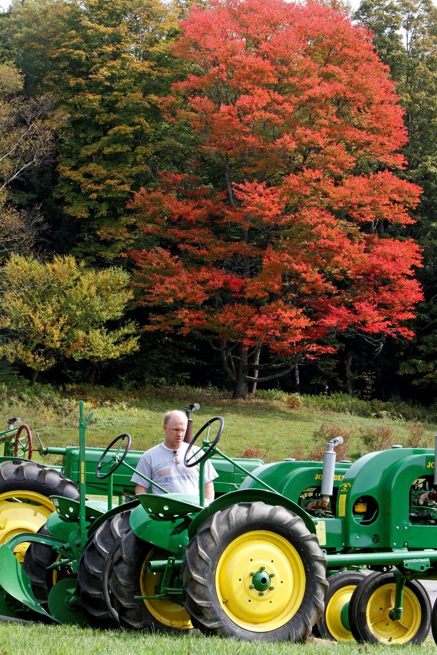 Fall foliage sets the backdrop as a visitor looks over antique tractors at the Morse Farm Maple Sugarworks in Montpelier, Vt. About 95 percent of Vermont's roads are open for tourists to enjoy the fall foliage season and other outdoor activities after the state was pounded by Tropical Storm Irene last month. (Associated Press)
