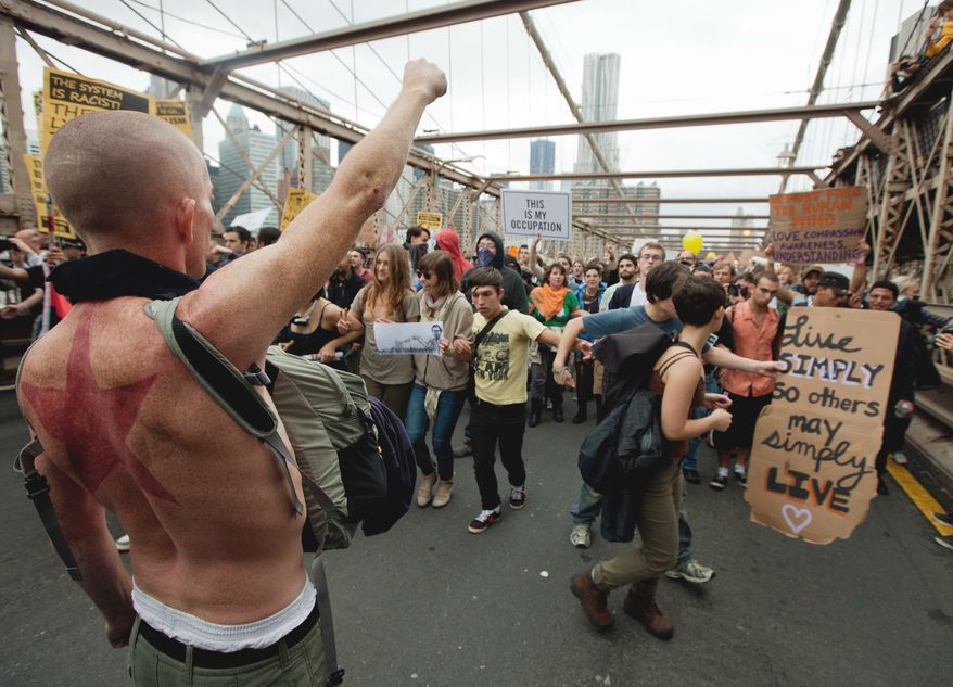 A large group of protesters affiliated with the Occupy Wall Street movement attempt to cross the Brooklyn Bridge, effectively shutting parts of it down, Saturday, Oct. 1, 2011, in New York. Police arrested dozens while trying to clear the road and reopen for traffic. (AP Photo/Will Stevens)