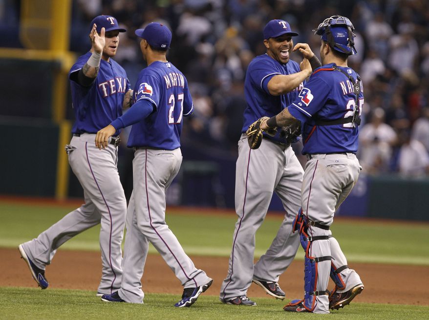 Texas Rangers catcher Mike Napoli, right, congratulates Nelson Cruz, as Leonys Martin (27) congratulates Josh Hamilton,left, at the end of Game 3 of baseball&#x27;s American League division series against the Tampa Bay Rays, Monday Oct. 2011 in St. Petersburg, Fla. The Rangers won 4-3 to lead the series 2-1. (AP Photo/Lynne Sladky)