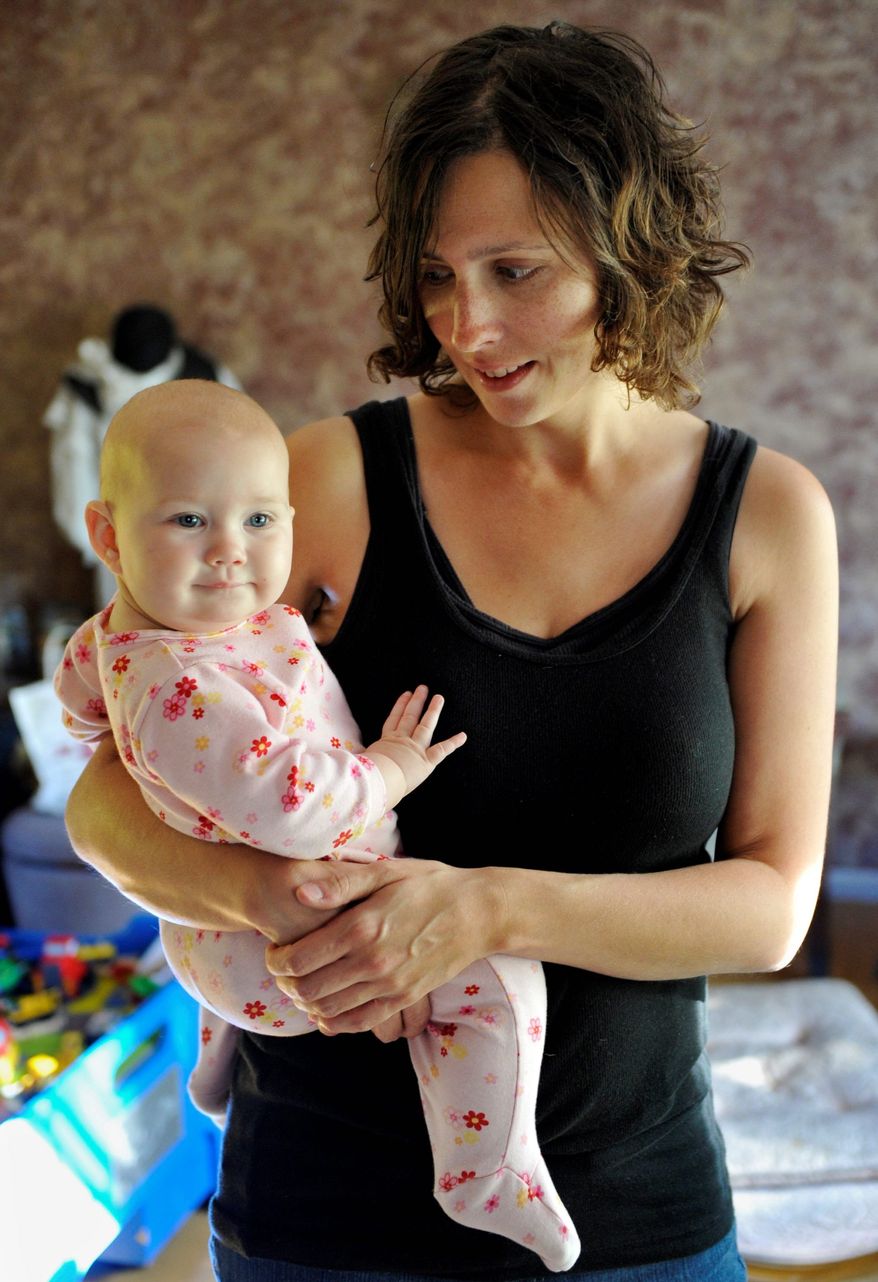 In this photo from Sept. 29, 2011, Kandace O'Neill poses with her 7-month-old daughter, in Lakeville, Minn. O'Neill's views on child vaccinations are shared by many parents who don't follow federal vaccine advice. Her 5-year-old son has had no vaccinations since he turned 1 and the baby girl has received none of the recommended shots. (Associated Press)