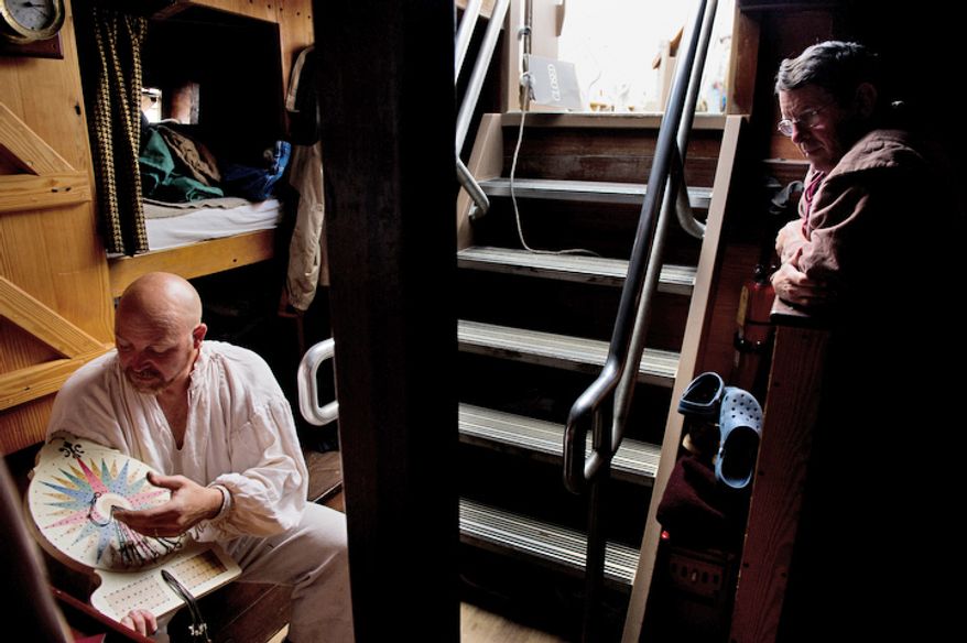 Volunteer ships crew member Pete Moxon, right, of Williamsburg, VA watches 1st mate Todd Egnor, left, of Williamsburg, VA repair a traverse board which helps plot course and speed while below deck on the Godspeed. (Andrew Harnik / The Washington Times)
