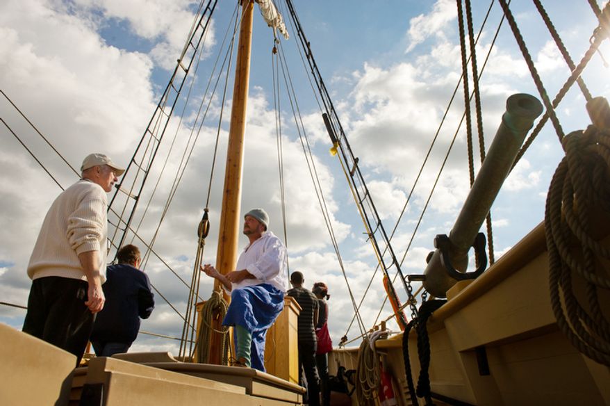 Nick Wigers, left, of St. Louis, Missouri speaks with staff member and Mate Whit Perry, center, of Deltaville, VA aboard the Godspeed, a re-creation of one of the three ships that brought AmericaÕs first permanent English colonists to Virginia in 1607. (Andrew Harnik / The Washington Times)