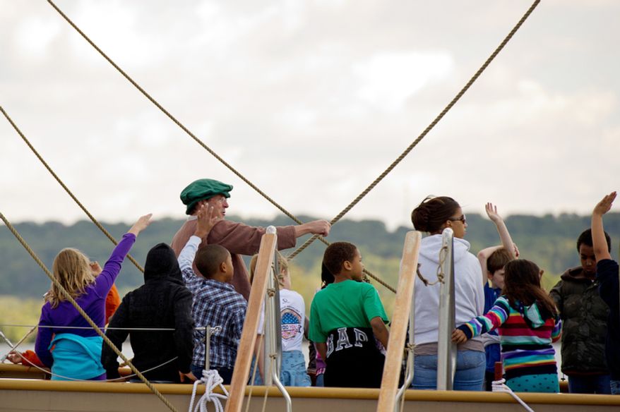 Volunteer ships crew member Pete Moxon, center left, of Williamsburg, VA teaches 4th graders from James Polk Elementary School in Alexandria, VA how to navigate aboard the Godspeed. (Andrew Harnik / The Washington Times)