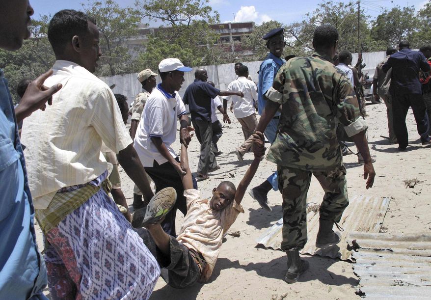 Somalis carry a wounded man at the scene of an explosion in Mogadishu, Somalia, Tuesday, Oct. 4, 2011. A rescue official says at least 55 people were killed after a car laden with explosives blew up in front of the Ministry of Education in the Somali capital of Mogadishu. (AP Photo/Mohamed Sheikh Nor)