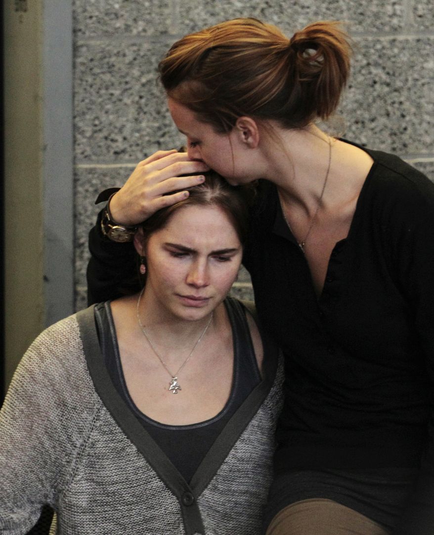 Amanda Knox (left) is comforted by her sister, Deanna Knox, during a news conference shortly after her arrival at Seattle-Tacoma International Airport on Oct. 4, 2011. (Associated Press)