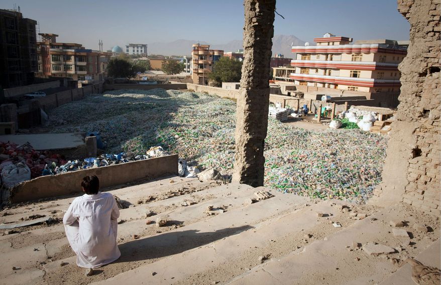 ASSOCIATED PRESS PHOTOGRAPHS
Bilal Khan, 19, looks out at the center of Kabul from the Taliban-razed cinema his family, including nine sisters, has made their home. Six months of interviews show life is grim for the average Afghan.