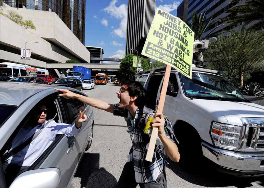A demonstrator protests in downtown Los Angeles as part of the Occupy Wall Street movement, Thursday, Oct. 6, 2011. The anti-Wall Street demonstrators say they're angry at big banks and corporate America. But they’re also deeply disgusted with politics and the inability of lawmakers to get things done in Washington. (AP Photo/Chris Carlson)
